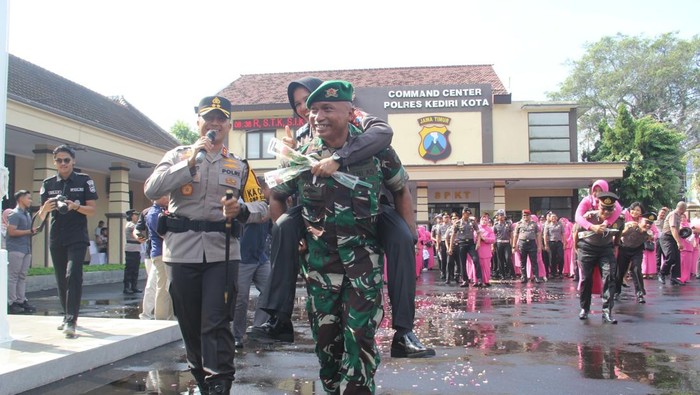 Letkol Inf A Wakhid Dedy Setyawan menggendong istri, Aiptu Ratna Rita Dewi usai naik pangkat di Mapolres Kediri Kota