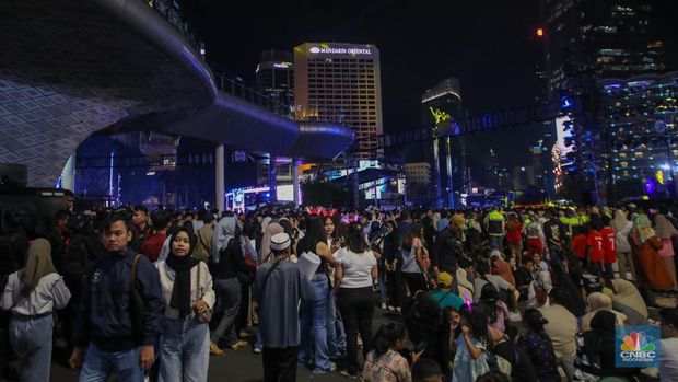 Warga memadati kawasan Bundaran Hotel Indonesia (HI) jelang malam pergantian tahun baru di Jakarta, Selasa (31/12/2024). (CNBC Indonesia/Faisal Rahman)