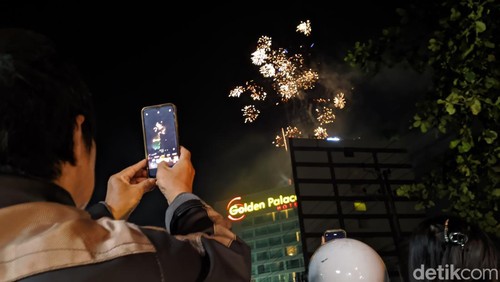 Warga menyaksikan letupan kembang api di salah satu hotel di Kota Mataram, NTB, Rabu (1/1/2025). (Foto: Ahmad Viqi/detikBali)