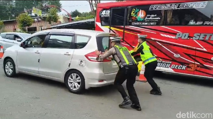 Anggota Polres Magetan Bantu Mendorong Kendaraan Mogok di Tanjakan
