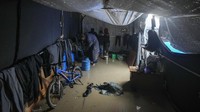 Warga terpaksa menggantung pakaian di rangka tenda pengungsian. 