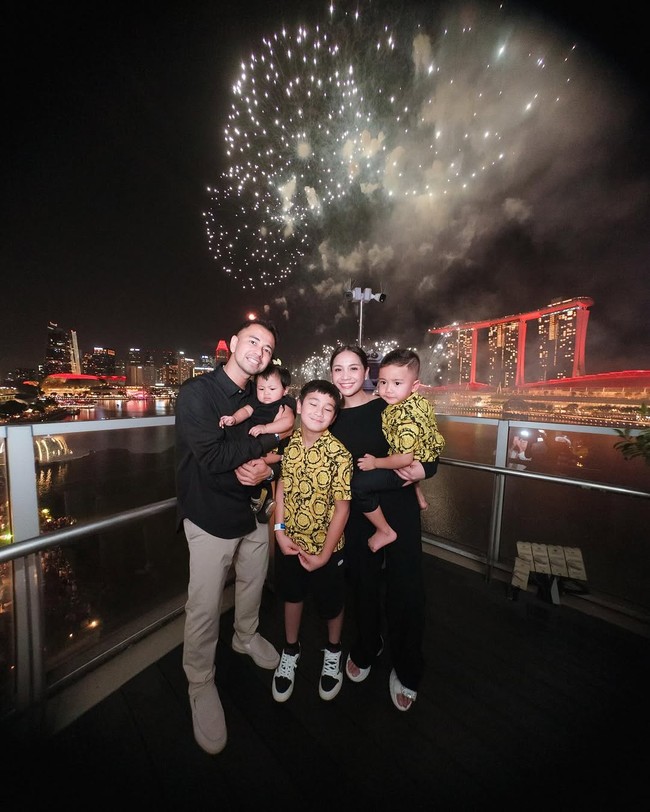 Pasangan selebriti Raffi Ahmad dan Nagita Slavina merayakan malam pergantian tahun 2025 di Singapura. Momen spesial ini semakin meriah karena mereka mengajak tiga anak mereka, Rafathar Malik Ahmad, Rayyanza Malik Ahmad, yang akrab disapa Cipung, dan Lily. (Foto: Instagram)