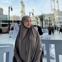 Pelantun Katakanlah Cinta itu berpose di depan Masjidil Haram dengan memakai setelan hijab syari dan dress.  Foto: Dok. Instagram @naura.ayu.