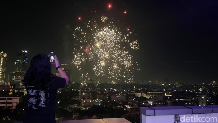Pesta kembang api menjadi momen ikonik malam pergantian tahun. Sejumlah warga Jakarta menyaksikannya dari gedung tinggi, Rabu (1/1/2025).