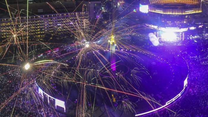 Potret Meriah Kembang Api Tahun Baru 2025 di Bundaran HI Fireworks explode as thousands of people gather in the main business district on New Year's Eve in Jakarta, Indonesia, Tuesday, Dec. 31, 2024. (AP Photo/Tatan Syuflana)