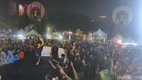 Pengunjung bersuka cita menikmati live music meski sedang turun hujan lebat di Pantai Losari, Makassar. Yaslinda Utari Kasim/detikSulsel