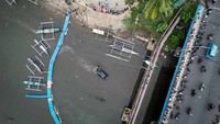 Foto udara sejumlah warga menyaksikan proses evakuasi mobil yang terjun ke sungai di Jembatan Megawati, Manado, Sulawesi Utara, Kamis (2/1/2025).