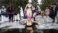 Temperatur yang membeku tidak menghalangi orang Kanada untuk memulai tahun baru dengan berendam di danau yang membeku. 