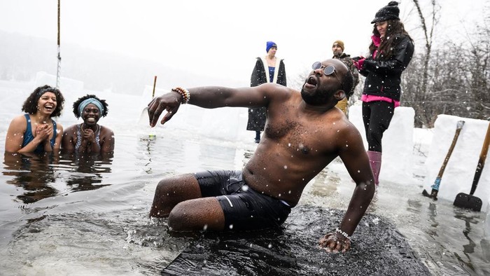 Brrr.. Warga Kanada Awali Tahun dengan Berendam di Danau Es Canda-Leigh Habonimana dips in the waters of Gatineau Park's Meech Lake in Chelsea, Que., during a polar bear dip on New Year's Day, Wednesday, Jan. 1, 2025. (Justin Tang /The Canadian Press via AP)