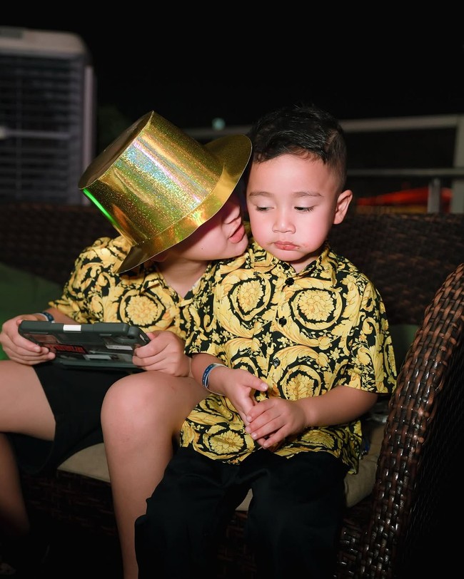 Kemeja yang dipakai keduanya merupakan salah satu dari koleksi pakaian anak dari rumah mode Italia Versace. Atasan tersebut hadir dalam motif barocco, estetika klasik rancangan mendiang desainer Gianni Versace.  (Foto: Instagram/@raffinagita1717)