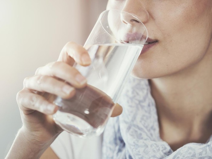 Young woman drinking pure glass of water