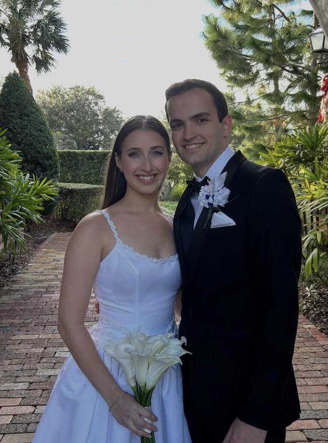 Gaun putih vintage tersebut memiliki potongan leher scoop-neck, detail payet berkilauan, serta rok mengembang. Bagian punggungnya dilengkapi pita besar yang menjuntai, memberikan kesan romantis dan klasik. Foto: dok. TikTok @juliasjems