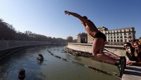 Puluhan orang ini melompat dari Jembatan Cavour setinggi 18 meter (59 kaki) untuk berenang di sungai Tiber. 
