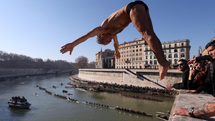Marco Fois dives into the Tiber River from the Cavour bridge, as part of traditional New Year celebrations, in Rome, Italy, January 1, 2025. REUTERS/Claudia Greco     TPX IMAGES OF THE DAY