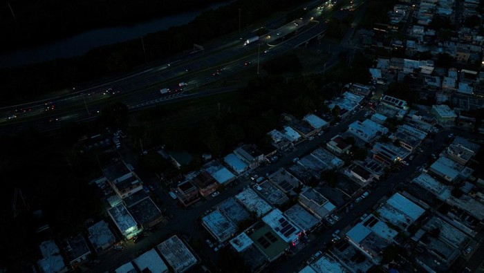 Puerto Rico Gelap Gulita Saat Tahun Baru A car drives through a dark street as Puerto Ricans were without electricity early on New Year's Eve after a grid failure left nearly all of the island without power, in San Juan, Puerto Rico December 31, 2024. REUTERS/Ricardo Arduengo