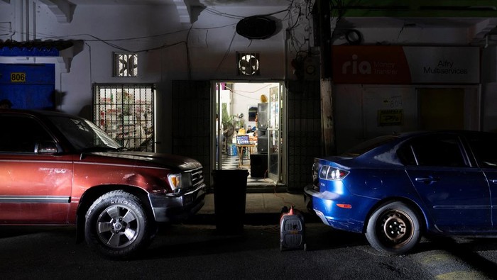 A car drives through a dark street as Puerto Ricans were without electricity early on New Year's Eve after a grid failure left nearly all of the island without power, in San Juan, Puerto Rico December 31, 2024.  REUTERS/Ricardo Arduengo