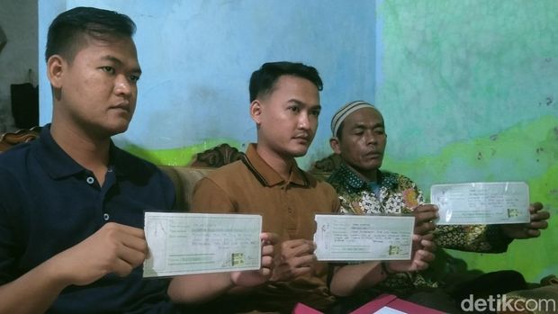 Suratmo (56) dan dua anaknya, warga Desa Pelutan, Kabupaten Pemalang, menunjukkan kuitansi penyerahan uang Rp 900 juta agar lolos jadi anggota Polri, Kamis (2/1/2025).
