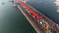 Saat matahari terbit di atas Selat Bosphorus, jembatan, yang merupakan landmark Istanbul yang dicintai, berubah menjadi hamparan bendera Turki dan Palestina yang semarak. 