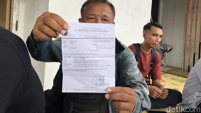 Salah satu pedagang, Kamto menunjukan undangan pengundian lapak yang ia terima ke awak media di kantor LBH Jogja, Kamis (2/12/2024).