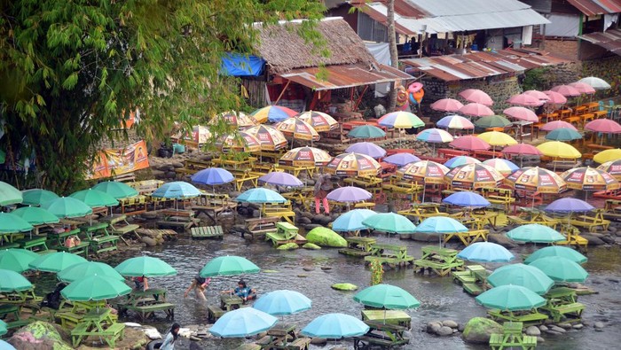 Asiknya Bersantai di Wisata Air Lubuk Lukum Padang Pengunjung menikmati wisata air di Lubuk Lukum, Padang, Sumatera Barat, Jumat (3/1/2025). Destinasi wisata air yang dikembangkan Kelompok Sadar Wisata (Pokdarwis) setempat itu memanfaatkan aliran sungai Batang Air Dingin sambil mengembangbiakkan ikan larangan jenis garing (Tor tambroides) dengan tiket masuk Rp5.000 per orang. ANTARA FOTO/Iggoy el Fitra/aww.