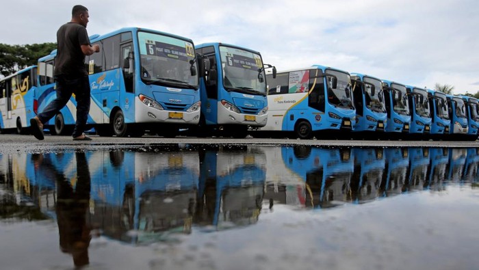Seorang pengemudi melintas di depan Bus Trans Koetaradja saat parkir di Terminal Batoh, Banda Aceh, Aceh, Jumat (3/1/2024). Menurut pemerintah Aceh, sebanyak 59 unit bus umum Trans Koetaradja yang selama ini melayani angkutan penumpang secara gratis dan mempekerjakan sebanyak 110 pekerja berhenti beroperasi karena berakhirnya kontrak kerja pada 31 Desember 2024 dan armada milik pemeritah itu akan kembali beroperasi pada Februari 2025 setelah dilakukan kontrak kerja baru.