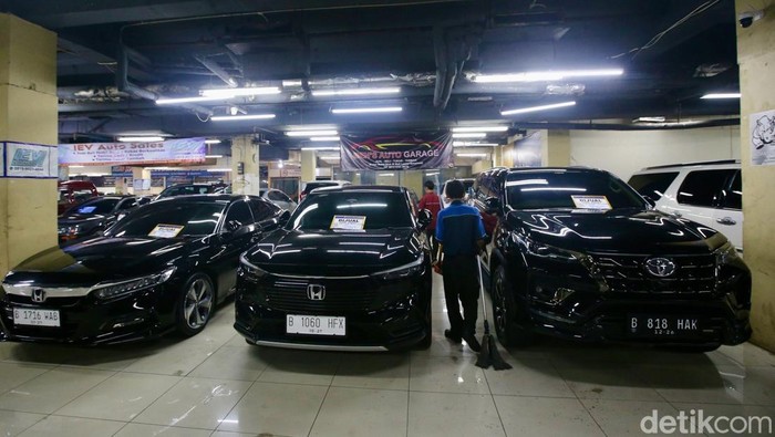 Pekerja merapikan interior mobil mewah bekas di tempat penjualan mobil bekas di Mal Blok M, Jakarta Selatan, Jumat (3/1/2025). Penjualan mobil bekas pada awal tahun 2025 relatif sepi. Kondisi tersebut diperburuk dengan melemahnya daya beli masyarat dan Pajak Pertambahan Nilai (PPN) 12 persen yang berlaku untuk barang mewah, termasuk mobil bekas.