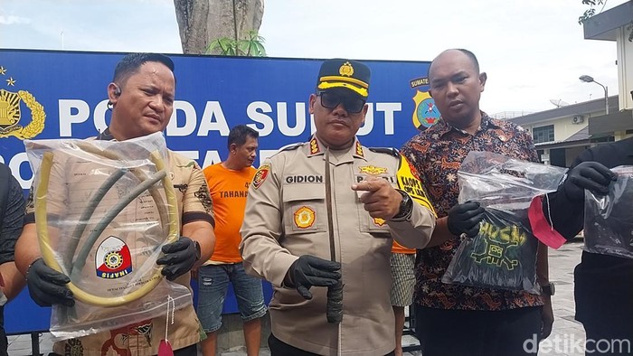 Kapolrestabes Medan Kombes Gidion saat menunjukkan parang yang digunakan pelaku menganiaya korban. (Finta Rahyuni/detikSumut)