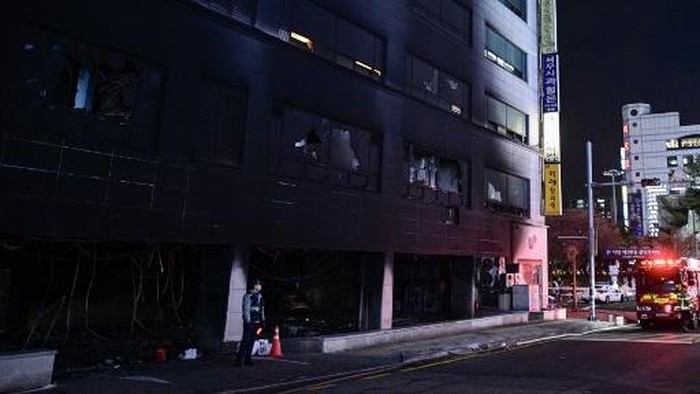 Investigators and firefighters are seen at the entrance of a damaged commercial building in the aftermath of a fire that broke out at the Bundang district in Seongnam on January 3, 2025. (Photo by Philip FONG / AFP)