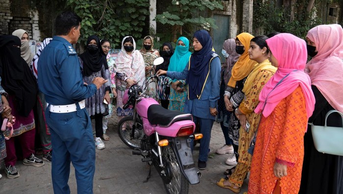 Humaira Rafaqat, a senior traffic warden, teaches women how to ride a bike while wearing an abaya, during a training session as part of the 