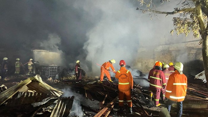 Petugas damkar saat melakukan pendinginan di gudang kayu yang terbakar. (Dok Istimewa)
