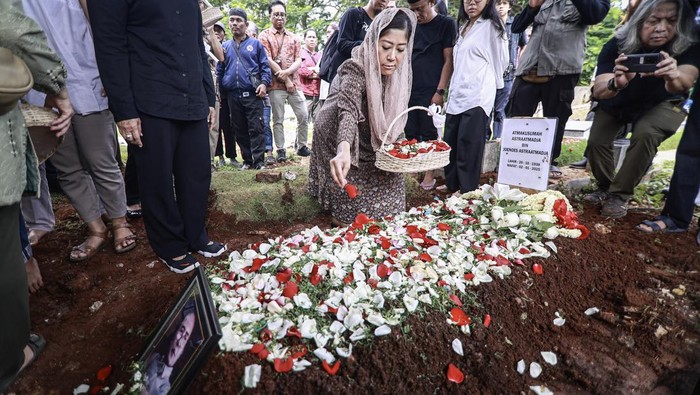 Potret Pemakaman Mantan Ketua Dewan Pers Atmakusumah Astraatmadja Kerabat menaburkan bunga di atas makam tokoh pers Atmakusumah Astraatmadja usai prosesi pemakaman di TPU Kebon Nanas, Jakarta, Jumat (3/1/2025). Atmakusumah Astraatmadja wafat pada hari Kamis (2/1/2025) pukul 13.05 WIB di Rumah Sakit Cipto Mangunkusumo (RSCM) Kencana pada usia 86 tahun. ANTARA FOTO/Dhemas Reviyanto/aww.