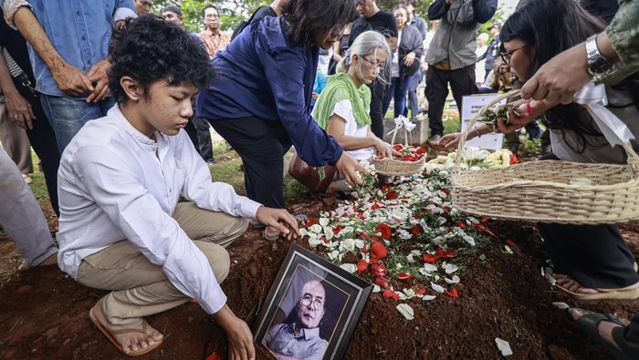 Potret Pemakaman Mantan Ketua Dewan Pers Atmakusumah Astraatmadja Kerabat menaburkan bunga di atas makam tokoh pers Atmakusumah Astraatmadja usai prosesi pemakaman di TPU Kebon Nanas, Jakarta, Jumat (3/1/2025). Atmakusumah Astraatmadja wafat pada hari Kamis (2/1/2025) pukul 13.05 WIB di Rumah Sakit Cipto Mangunkusumo (RSCM) Kencana pada usia 86 tahun. ANTARA FOTO/Dhemas Reviyanto/aww.