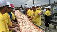 Pizzaovens.com mengumpulkan 100 partisipan untuk membuat pizza terpanjang di dunia. Dalam percobaannya mereka berhasil menyajikan pizza sepanjang 1.853 meter. Foto: Guinness Book of World Records