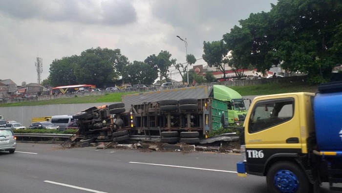 Satu unit truk kontainer mengalami kecelakaan tunggal di Tol Jakarta Outer Ring Road (JORR). Truk tersebut terguling di median jalan. (dok TMC Polda Metro Jaya)