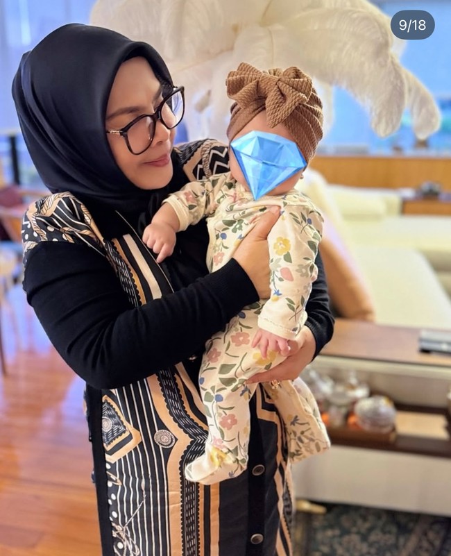 Putri kecil Syahrini itu juga kerap didandani dengan busana-busana lucu yang membuatnya makin menggemaskan. Seperti dalam foto, baby R tampak mengenakan sleepsuit bermotif floral dipadukan dengan tutup kepala berpita warna coklat. Foto: Instagram/@princessyahrini