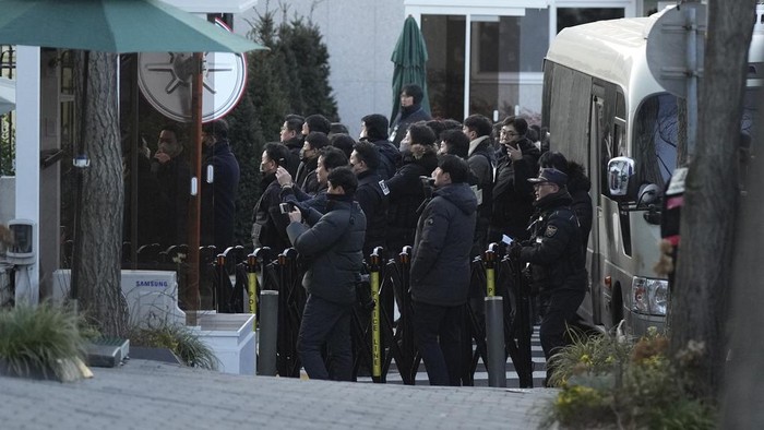 Police officers arrive at the gate of the presidential residence as supporters of impeached South Korean President Yoon Suk Yeol stage a rally to oppose a court having issued a warrant to detain Yoon, in Seoul, South Korea, Friday, Jan. 3, 2025. (AP Photo/Lee Jin-man)