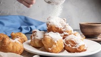 Tampilannya seperti donat, inilah beignet yang populer di Paris. Biasanya disajikan dengan gula tabur. Untuk membacanya yang benar adalah ben-YE. Foto: Insider