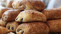 Biasanya ditawarkan bersama croissant, inilah pain au chocolat yang merupakan pastry isi cokelat khas Prancis. Kamu bisa menyebutnya pan-oh-shoh-koh-lah. Foto: Insider