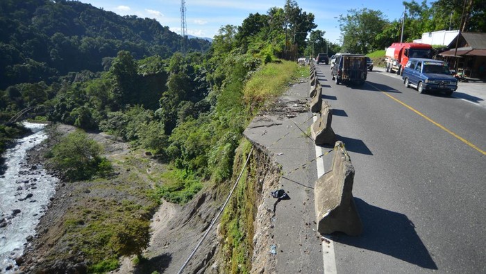 Kendaraan melintas samping bahu jalan yang longsor di jalan raya Padang - Bukittinggi, Malibo Anai, Padang Pariaman, Sumatera Barat, Sabtu (4/01/2025). Longsoran di jalan nasional itu semakin meluas dan dapat membahayakan pengendara kendaraan. ANTARA FOTO/Iggoy el Fitra/Spt.