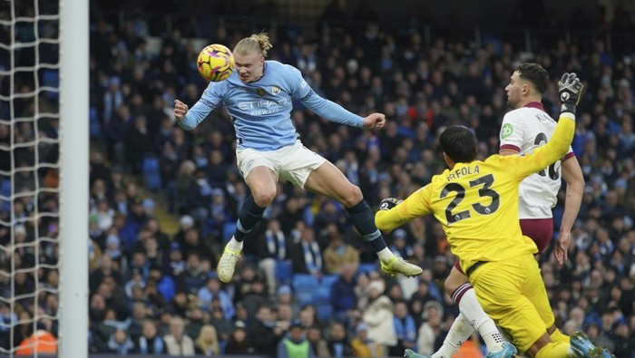 Manchester Citys Erling Haaland, left, scores his sides 2nd goal against West Ham during a English Premier League soccer match at Etihad stadium in Manchester, England, Saturday, Jan. 4, 2025. (AP Photo/Ian Hodgson)