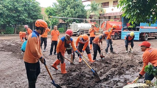 Bersih-bersih material banjir di Kecamatan Rengel Tuban.