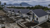 Pekerja mengecat dinding rumah hunian tetap (huntap) untuk korban banjir bandang di Rua, Kelurahan Jambula, Ternate, Maluku Utara, Minggu (5/1/2025).
