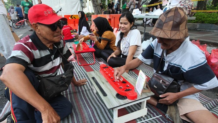 Pecinta satwa bermain dengan ular Sanca saat Hari Bebas Kendaraan Bermotor (Car Free Day) di Jalan Darmo, Surabaya, Jawa Timur, Minggu (5/1/2025). Hari Bebas Kendaraan Bermotor yang digelar untuk meningkatkan kualitas udara dan mendorong aktivitas gaya hidup sehat digelar kembali pada hari Minggu pertama di tahun 2025 setelah pada 29 Desember 2024 ditiadakan. ANTARA FOTO/Didik Suhartono/rwa.