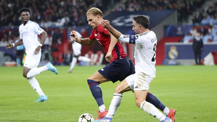 LILLE, FRANCE - OCTOBER 2: Mitchel Bakker of Lille, Daniel Carvajal of Real Madrid during the UEFA Champions League 2024/25 League Phase MD2 match between Lille OSC (LOSC) and Real Madrid C.F. at Stade Pierre Mauroy, Decathlon Arena on October 2, 2024 in Villeneuve dAscq near Lille, France. (Photo by Jean Catuffe/Getty Images)