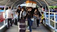 Dengan membawa kardus hingga koper, mereka berjalan menuju dermaga Pelabuhan Pelindo Dumai untuk menaiki kapal penyeberangan. 
