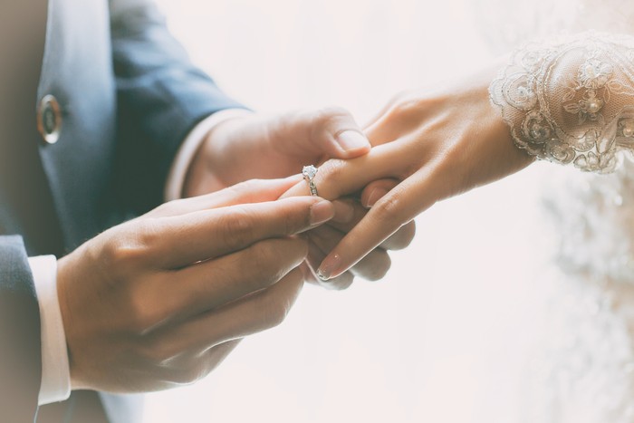 Couple wearing wedding ring at wedding day of them.