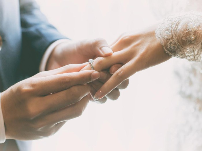Couple wearing wedding ring at wedding day of them.