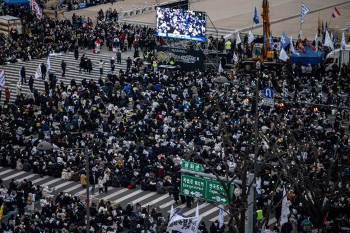 Supporters of impeached South Korea president Yoon Suk Yeol take part in a rally near his residence as snow falls in Seoul on January 5, 2025. Rival South Korean protesters were set to brave a snowstorm January 5 over suspended President Yoon Suk Yeol who was still resisting arrest less than 48 hours before the warrant expires. (Photo by Philip FONG / AFP)