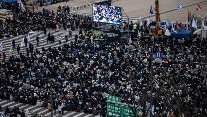 Supporters of impeached South Korea president Yoon Suk Yeol take part in a rally near his residence as snow falls in Seoul on January 5, 2025. Rival South Korean protesters were set to brave a snowstorm January 5 over suspended President Yoon Suk Yeol who was still resisting arrest less than 48 hours before the warrant expires. (Photo by Philip FONG / AFP)