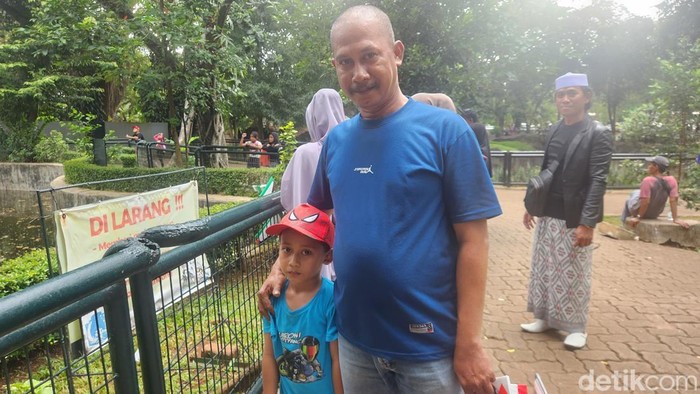 Warga Jaktim, Nasrul (45) dan anaknya berlibur ke TM Ragunan (Adrial/detikcom)